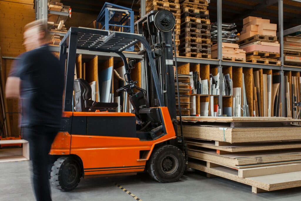Forklift kuning dan hitam di dalam gudang